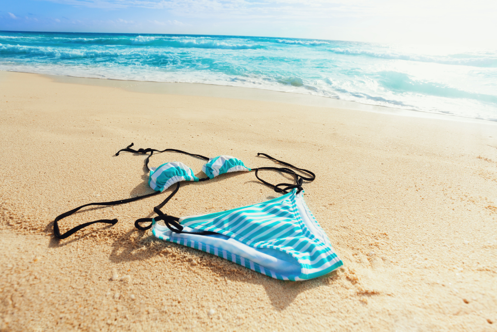 swimsuit laying flat on the sand by the beach
