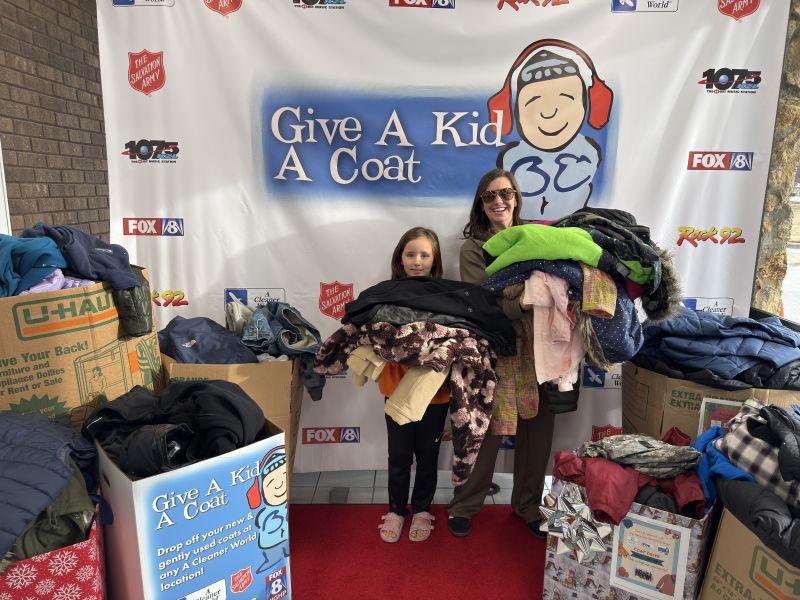 People donating coats at the 2026 Give A Kid A Coat kickoff event